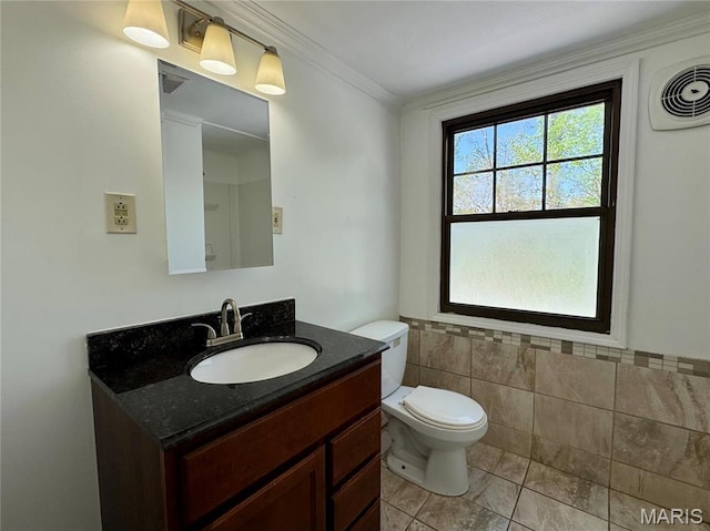 half bath featuring toilet, tile patterned floors, vanity, tile walls, and ornamental molding