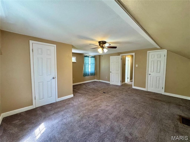 additional living space with carpet floors, a ceiling fan, baseboards, and a textured ceiling