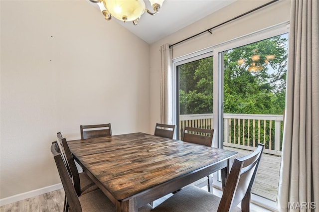 1421 N Woods Dr, Festus, MO 63028 - dining space with healthy amount of natural light, a chandelier, lofted ceiling, wood finished floors, and baseboards