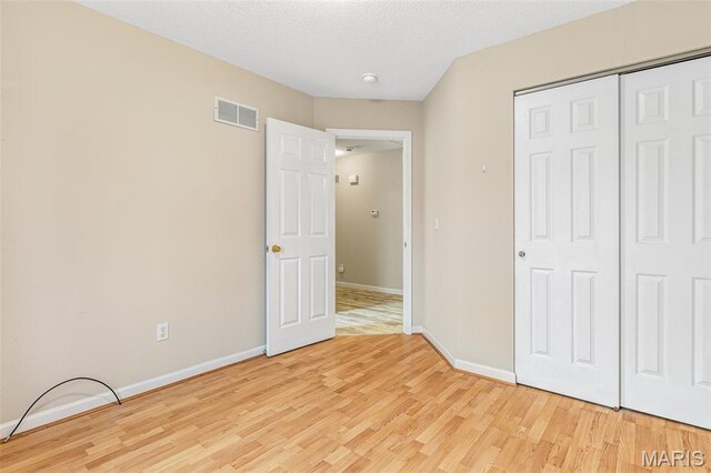 1421 N Woods Dr, Festus, MO 63028 - unfurnished bedroom with light wood-style floors, baseboards, and a closet