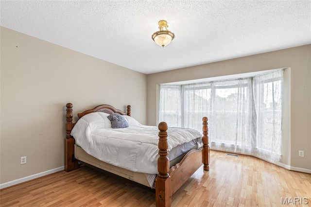 1421 N Woods Dr, Festus, MO 63028 - bedroom featuring light wood-style floors, baseboards, and a textured ceiling