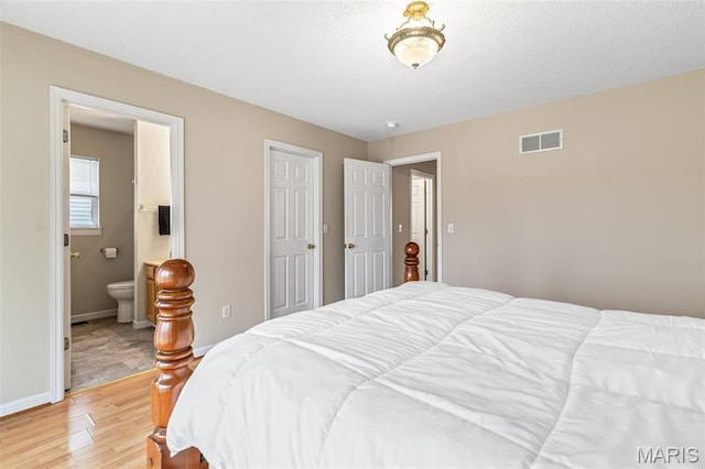 1421 N Woods Dr, Festus, MO 63028 - bedroom with light wood-style flooring, baseboards, and ensuite bath