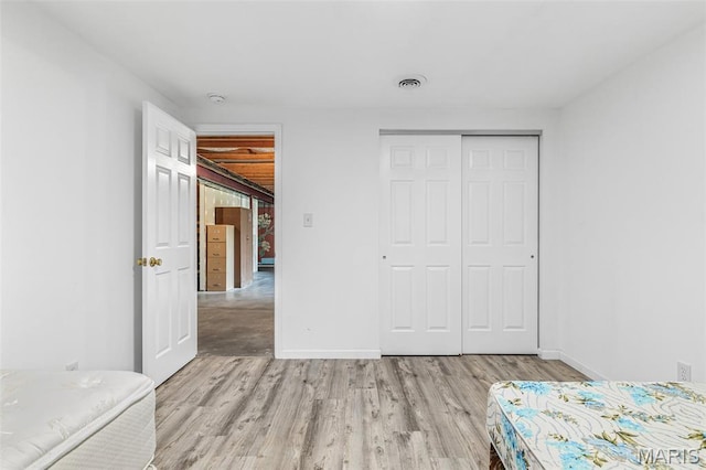 1421 N Woods Dr, Festus, MO 63028 - unfurnished bedroom featuring light wood-style floors, a closet, and baseboards
