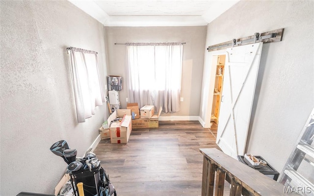 10771 Crest Rd, Dixon, MO 65459 - living area featuring a barn door, wood finished floors, a textured wall, and baseboards