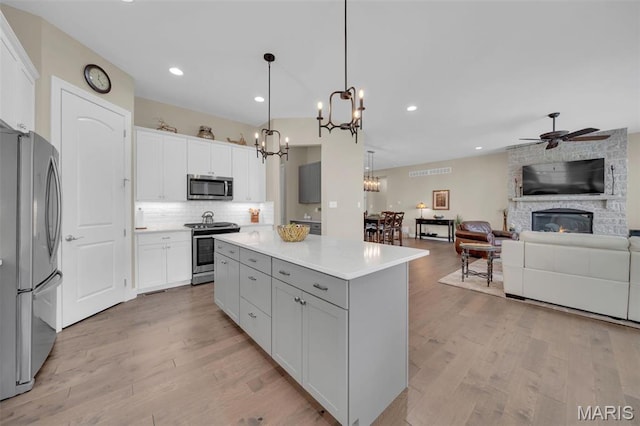 501 Upper Ridgepointe Ct, Lake St Louis, MO 63367 - kitchen with stainless steel appliances, a chandelier, light wood-style floors, ceiling fan, and tasteful backsplash