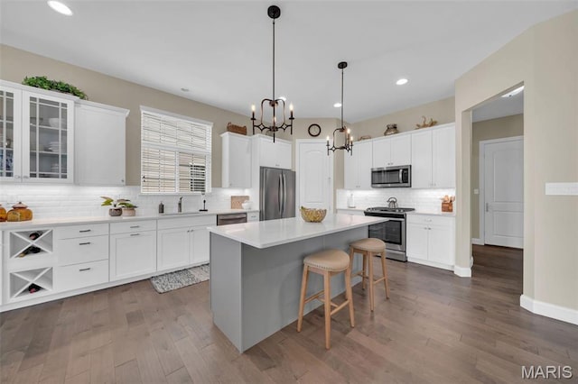 501 Upper Ridgepointe Ct, Lake St Louis, MO 63367 - kitchen with appliances with stainless steel finishes, a chandelier, a kitchen island, white cabinets, and recessed lighting