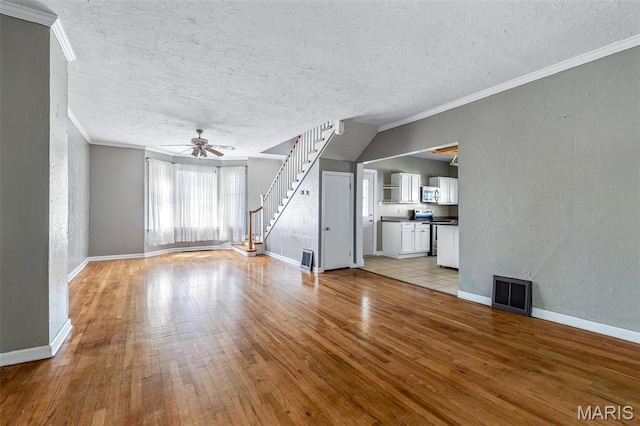 323 N Division St, Bonne Terre, MO 63628 - unfurnished living room featuring a textured wall, light wood-style floors, ceiling fan, baseboards, and a textured ceiling