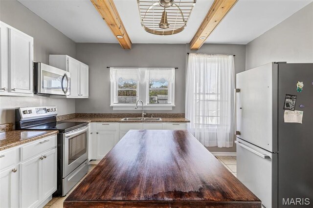 323 N Division St, Bonne Terre, MO 63628 - kitchen with stainless steel appliances, a sink, healthy amount of natural light, beamed ceiling, and white cabinetry