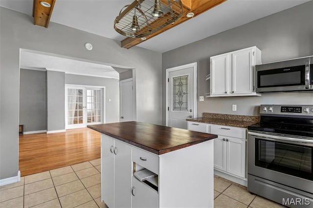 323 N Division St, Bonne Terre, MO 63628 - kitchen featuring stainless steel appliances, light tile patterned floors, butcher block countertops, white cabinets, and beamed ceiling