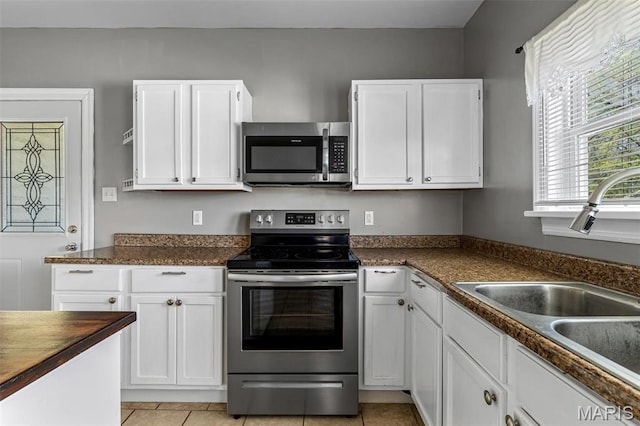 323 N Division St, Bonne Terre, MO 63628 - kitchen featuring stainless steel appliances, a sink, dark countertops, and white cabinets