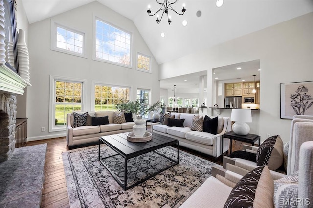 1264 Wilton Ln, Saint Louis, MO 63122 - living area with a chandelier, high vaulted ceiling, hardwood / wood-style flooring, a stone fireplace, and recessed lighting