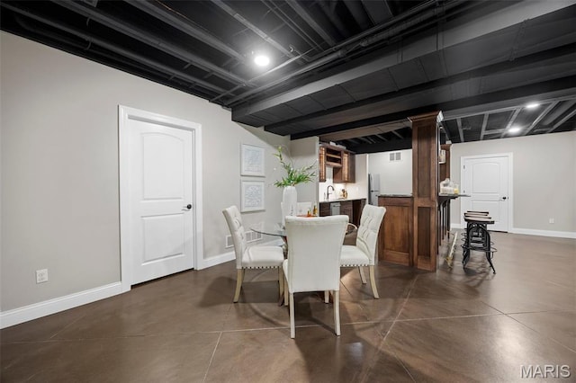 1264 Wilton Ln, Saint Louis, MO 63122 - dining area with concrete flooring, baseboards, and bar area