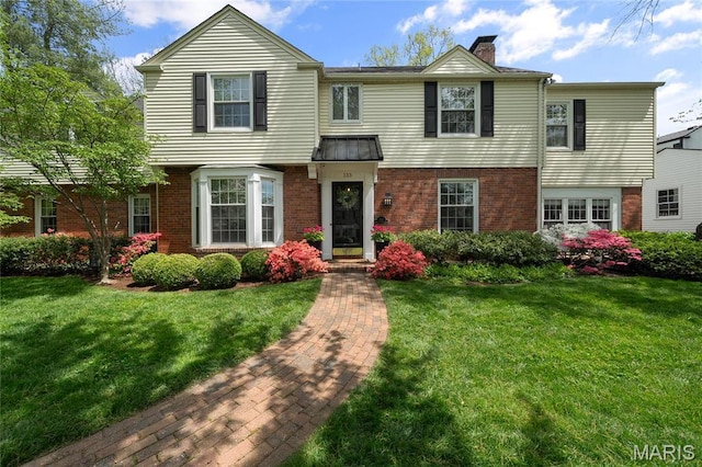 133 Webster Woods Dr, Saint Louis, MO 63119 - view of front of home with brick siding, a chimney, and a front lawn