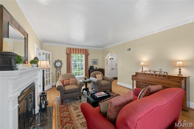133 Webster Woods Dr, Saint Louis, MO 63119 - living area featuring arched walkways, ornamental molding, wood finished floors, baseboards, and a high end fireplace