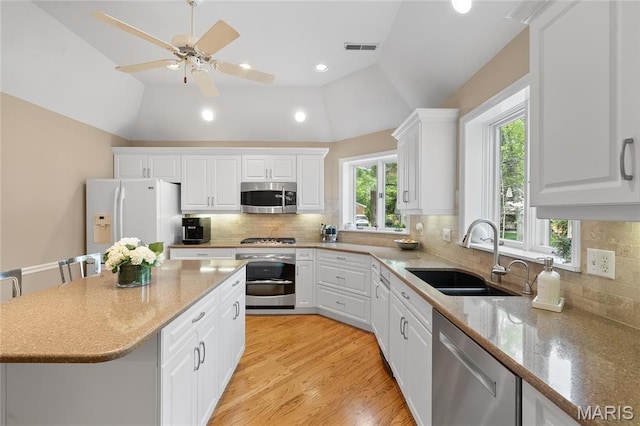133 Webster Woods Dr, Saint Louis, MO 63119 - kitchen with stainless steel appliances, a sink, vaulted ceiling, white cabinets, and recessed lighting