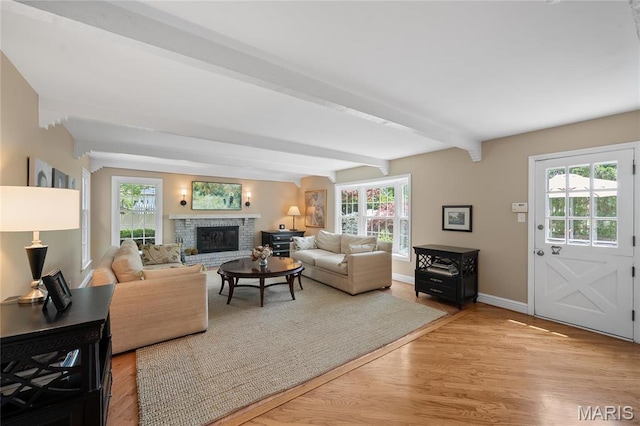133 Webster Woods Dr, Saint Louis, MO 63119 - living room featuring beamed ceiling, healthy amount of natural light, baseboards, light wood-type flooring, and a glass covered fireplace