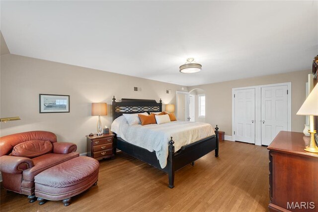 133 Webster Woods Dr, Saint Louis, MO 63119 - bedroom with arched walkways, light wood-type flooring, baseboards, and a closet