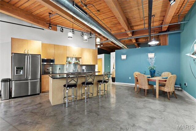 901 Washington Ave Unit 605, Saint Louis, MO 63101 - kitchen featuring stainless steel appliances, dark countertops, finished concrete floors, baseboards, and beamed ceiling