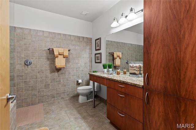 901 Washington Ave Unit 605, Saint Louis, MO 63101 - full bathroom featuring tile walls, toilet, vanity, and a walk in shower