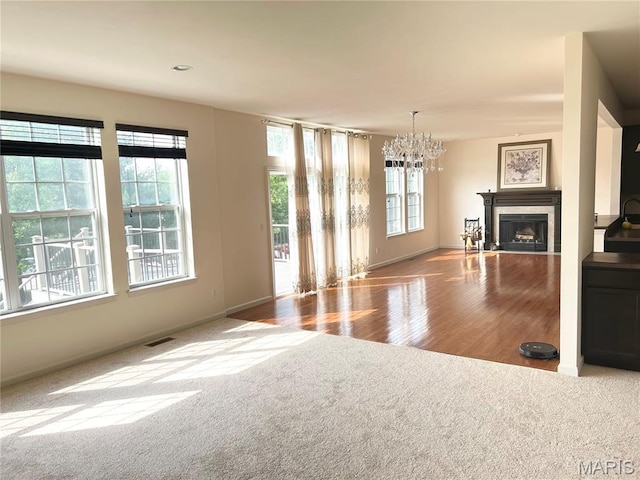 833 Harding St, Saint Peters, MO 63376 - unfurnished living room with carpet floors, a chandelier, a fireplace, baseboards, and wood finished floors