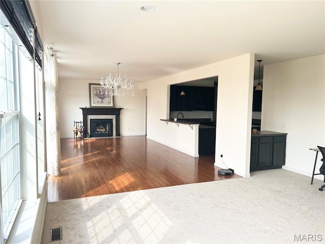 833 Harding St, Saint Peters, MO 63376 - unfurnished living room with a chandelier, wood finished floors, a fireplace, and baseboards