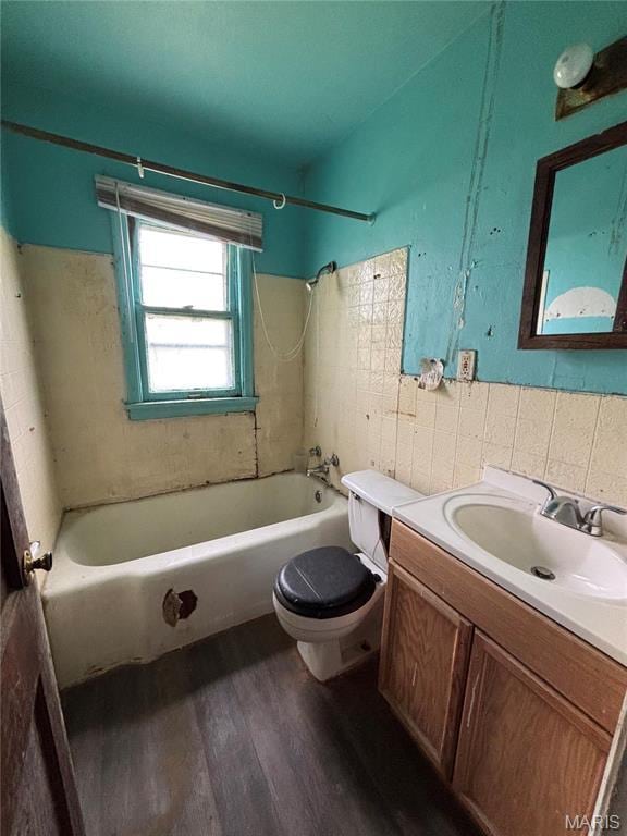 510 Ames Pl, Ferguson, MO 63135 - bathroom featuring wood finished floors, toilet, shower / washtub combination, tile walls, and vanity