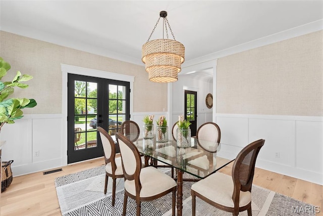 705 W Lockwood Ave, Glendale, MO 63122 - dining space featuring wainscoting, french doors, wood finished floors, a chandelier, and wallpapered walls