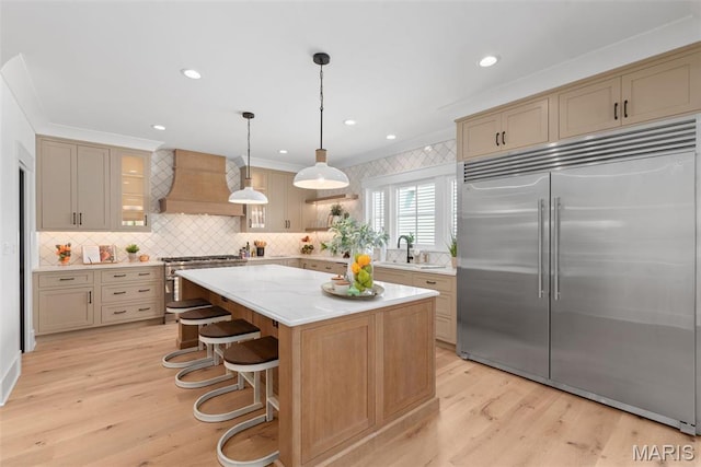 705 W Lockwood Ave, Glendale, MO 63122 - kitchen with high quality appliances, custom range hood, a kitchen island, light wood-style floors, and recessed lighting