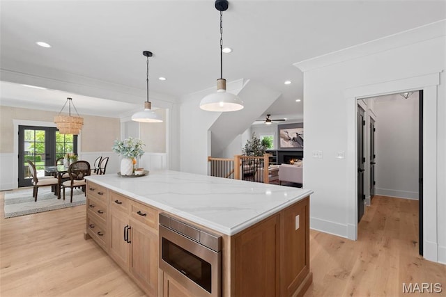 705 W Lockwood Ave, Glendale, MO 63122 - kitchen featuring stainless steel microwave, light wood-style floors, decorative light fixtures, wainscoting, and recessed lighting