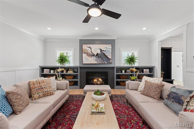 705 W Lockwood Ave, Glendale, MO 63122 - living room with a decorative wall, crown molding, a ceiling fan, wood finished floors, and a glass covered fireplace