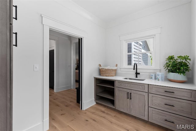 705 W Lockwood Ave, Glendale, MO 63122 - bar featuring a sink, light wood finished floors, and baseboards