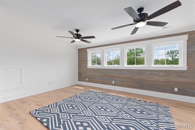 705 W Lockwood Ave, Glendale, MO 63122 - unfurnished bedroom with wood walls, baseboards, light wood finished floors, and ceiling fan