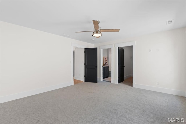705 W Lockwood Ave, Glendale, MO 63122 - unfurnished bedroom featuring baseboards, light colored carpet, a ceiling fan, and a walk in closet