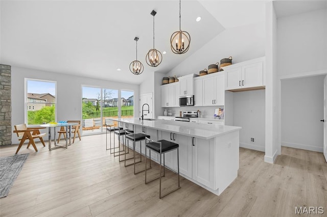 6345 Gibison Rd, Troy, MO 63379 - kitchen featuring stainless steel appliances, a sink, a chandelier, white cabinetry, and high vaulted ceiling