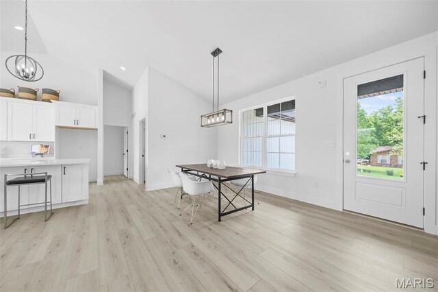6345 Gibison Rd, Troy, MO 63379 - dining space with light wood-type flooring, a chandelier, high vaulted ceiling, and baseboards