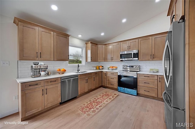 10204 Riehl Farm Dr, Potosi, MO 63664 - kitchen featuring appliances with stainless steel finishes, lofted ceiling, light wood finished floors, decorative backsplash, and light countertops