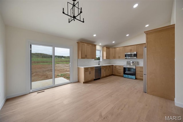 10204 Riehl Farm Dr, Potosi, MO 63664 - kitchen featuring stainless steel appliances, tasteful backsplash, light wood-style flooring, light countertops, and vaulted ceiling