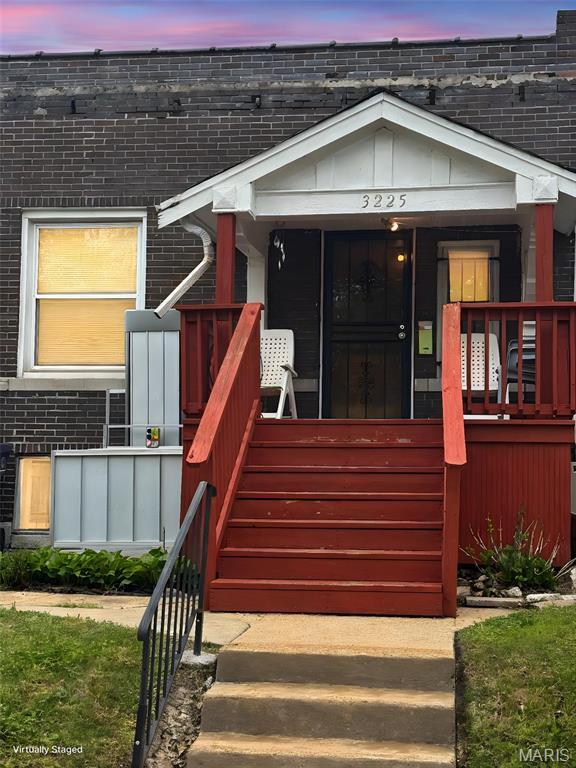 3225 N Taylor Ave, Saint Louis, MO 63115 - exterior entry at dusk with brick siding and covered porch