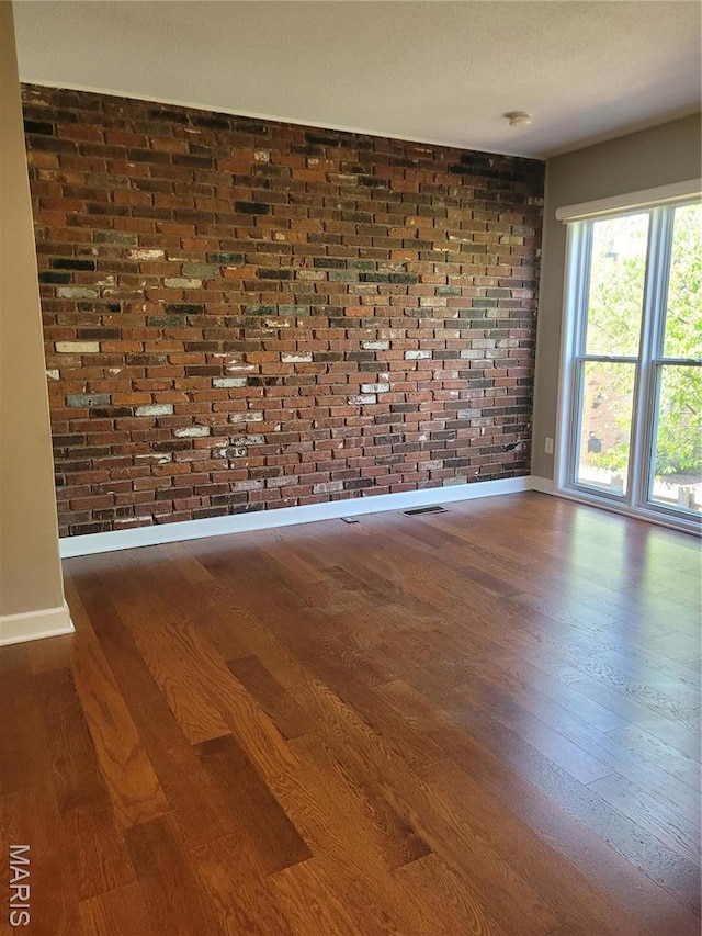 12859 Town And Four Dr Unit 12859, Creve Coeur, MO 63141 - unfurnished room with wood finished floors, baseboards, and brick wall
