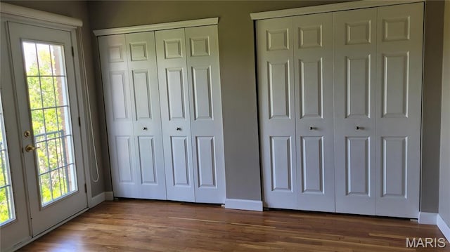 12859 Town And Four Dr Unit 12859, Creve Coeur, MO 63141 - unfurnished bedroom with multiple closets, multiple windows, baseboards, and wood finished floors