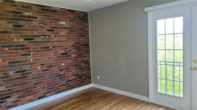 12859 Town And Four Dr Unit 12859, Creve Coeur, MO 63141 - unfurnished room with baseboards, wood finished floors, and brick wall