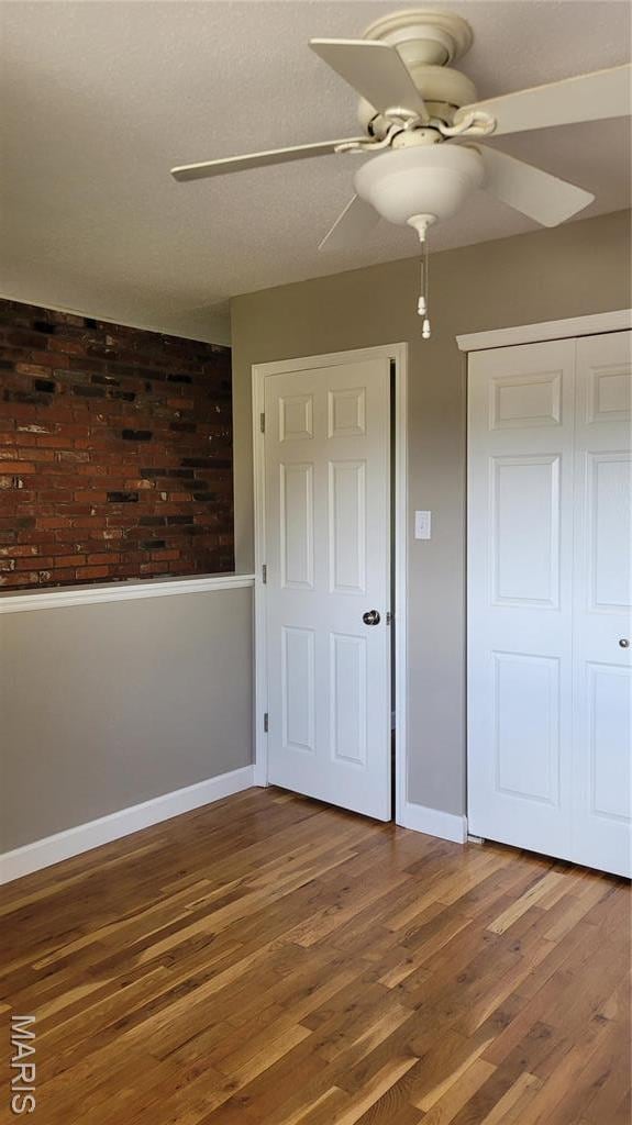 12859 Town And Four Dr Unit 12859, Creve Coeur, MO 63141 - unfurnished bedroom featuring wood finished floors, baseboards, a closet, and a ceiling fan