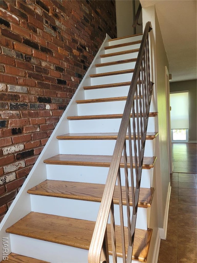 12859 Town And Four Dr Unit 12859, Creve Coeur, MO 63141 - stairway featuring tile patterned floors, baseboards, and brick wall