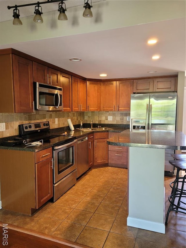12859 Town And Four Dr Unit 12859, Creve Coeur, MO 63141 - kitchen featuring appliances with stainless steel finishes, a breakfast bar, decorative backsplash, a sink, and recessed lighting