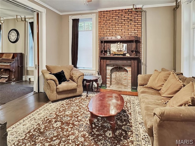 living room featuring wood finished floors, crown molding, and a brick fireplace