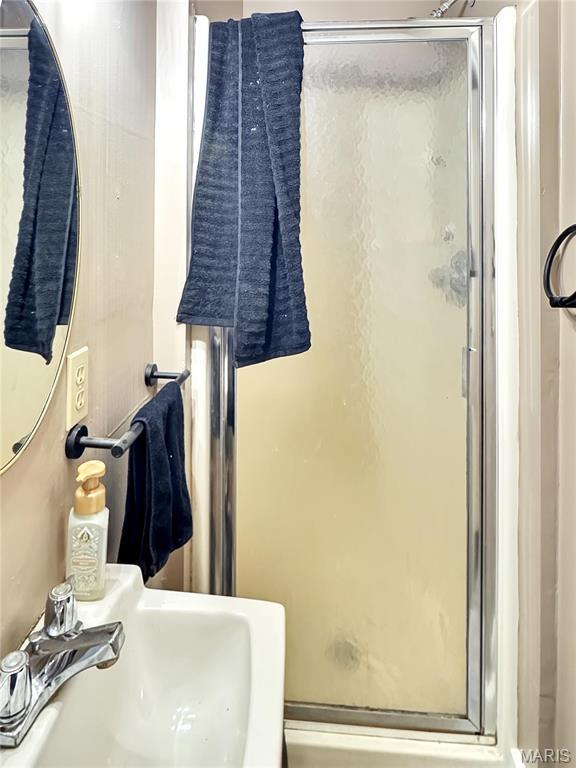 full bath featuring a sink and a shower stall