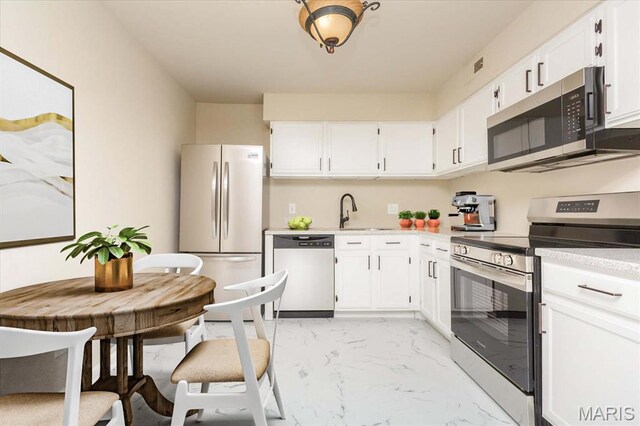 149 Jubilee Hill Dr Unit H, Grover, MO 63040 - kitchen with appliances with stainless steel finishes, light marble finish floors, a sink, light countertops, and white cabinets