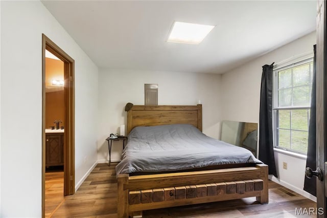 14276 State Route 21, De Soto, MO 63020 - bedroom with wood finished floors, multiple windows, baseboards, and a sink