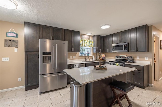2250 Pinta Dr, Warrenton, MO 63383 - kitchen with appliances with stainless steel finishes, a sink, light tile patterned floors, and dark brown cabinets