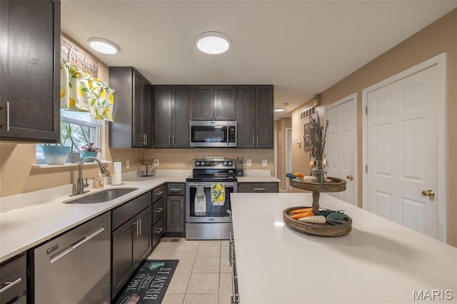 2250 Pinta Dr, Warrenton, MO 63383 - kitchen with appliances with stainless steel finishes, a sink, light countertops, dark brown cabinetry, and light tile patterned floors